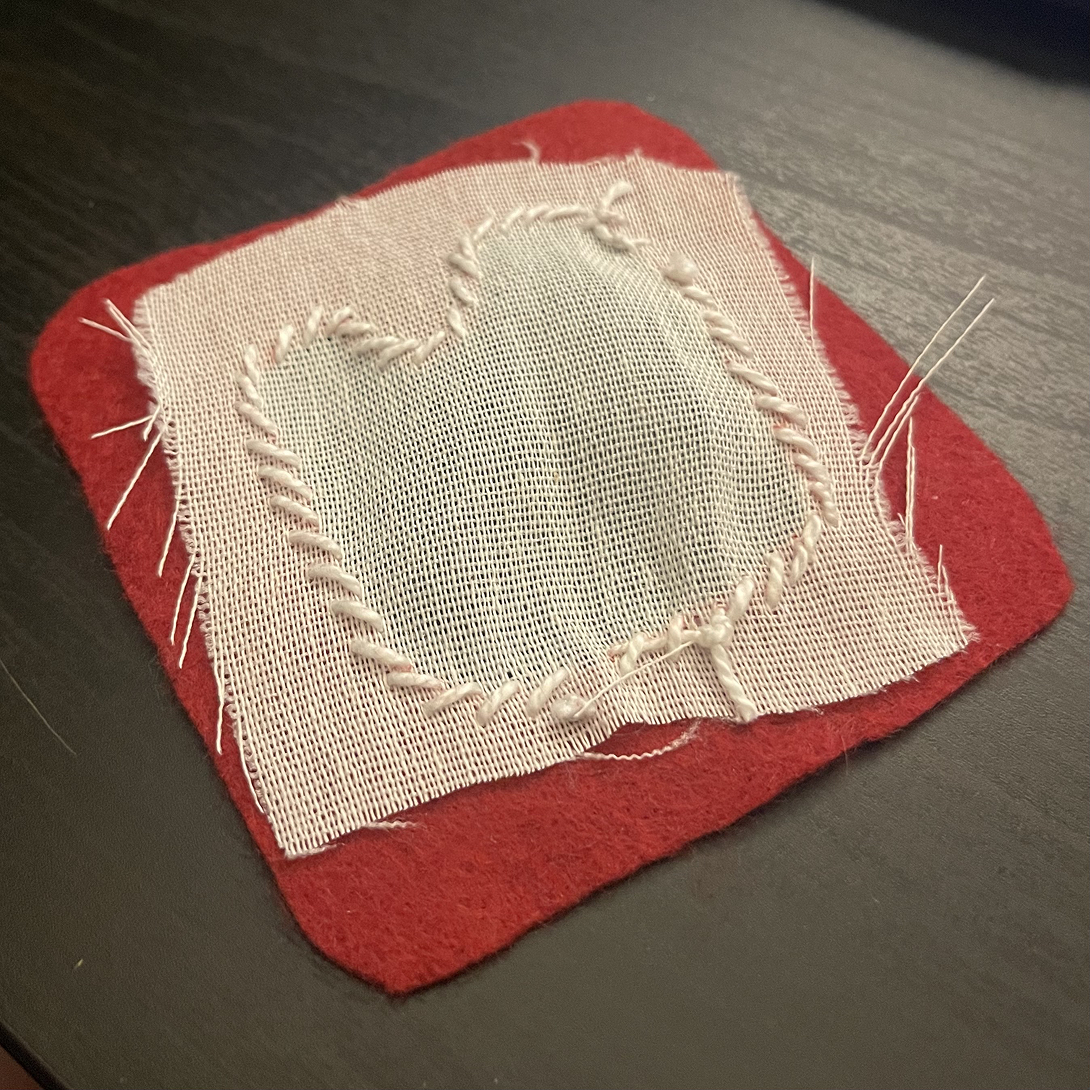 I sewed the light lining of the patch first, attaching it to the red felt border. I then cut a hole where the little bump is to make room for the sensor.